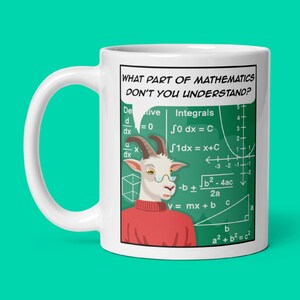 Puede incluir: Taza de cerámica blanca con una cabra de dibujos animados que lleva un suéter rojo y gafas. La cabra está de pie frente a una pizarra verde con ecuaciones matemáticas y el texto "WHAT PART OF MATHEMATICS DON'T YOU UNDERSTAND?"
