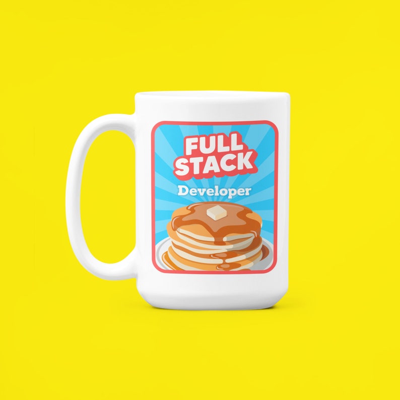 K&ouml;nnte beinhalten: Wei&szlig;e Keramiktasse mit einer blauen, roten und wei&szlig;en Grafik eines Stapels Pfannkuchen mit Sirup und einer Butterflocke. Die Grafik lautet "Full Stack Developer" in roten und wei&szlig;en Buchstaben.