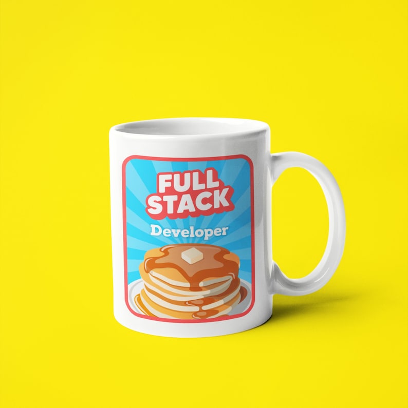K&ouml;nnte beinhalten: Wei&szlig;e Keramiktasse mit einer blauen, roten und wei&szlig;en Grafik eines Stapels Pfannkuchen mit dem Text "Full Stack Developer" auf wei&szlig;em Hintergrund.