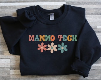Puede incluir: Sudadera negra con el texto "MAMMO TECH" en letras retro de colores y tres gráficos de flores de colores.