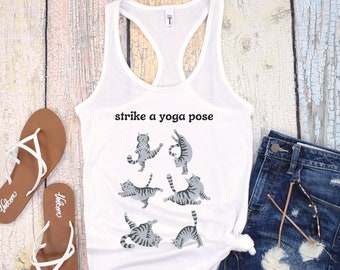 May include: White tank top with the text "strike a yoga pose" and a graphic of six gray cats in different yoga poses.