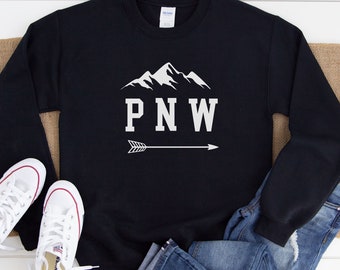May include: Black sweatshirt with a white mountain graphic and the text "PNW" with an arrow pointing to the right.