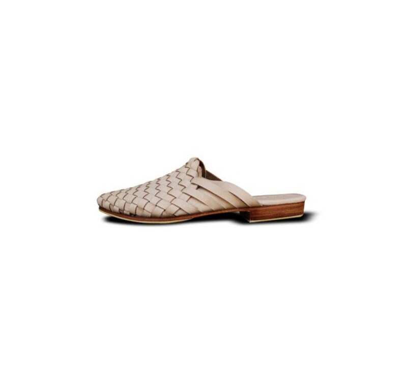 May include: A pair of woven leather sandals in a light beige colour with a brown leather sole.