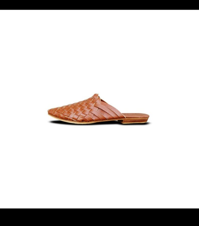 May include: A pair of brown leather woven slip-on shoes with a pointed toe.