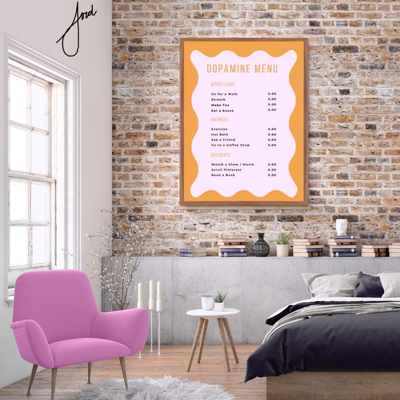 May include: A framed poster with a pink and orange background. The poster has the title "Dopamine Menu" and lists activities with prices. The poster is hanging on a brick wall in a room with a pink armchair, a white side table, and a bed with a gray duvet.