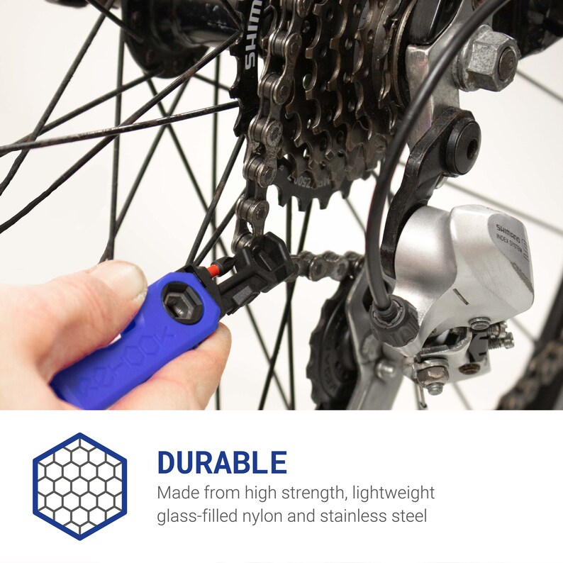 Pode incluir: Uma ferramenta de corrente de bicicleta azul com uma pega preta. A ferramenta est&aacute; sendo usada para remover um elo de uma corrente de bicicleta. A corrente est&aacute; presa a um desviador traseiro de bicicleta.