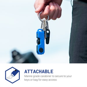 Pode incluir: Uma ferramenta multifuncional azul com um mosquet&atilde;o preso a um chaveiro. A ferramenta multifuncional tem a palavra "REHOOK" impressa no lado. O texto "ATTACHABLE" est&aacute; impresso abaixo da imagem. O texto diz "Mosquet&atilde;o de grau marinho para prender &agrave;s suas chaves ou bolsa para f&aacute;cil acesso."