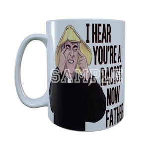 May include: White ceramic mug with a handle, featuring a cartoon image of a person with a yellow hat and the text "I HEAR YOU'RE A RACIST NOW FATHER". The mug has a white background.