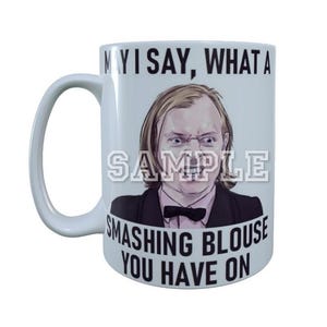 May include: White ceramic mug with a black and white illustration of a person wearing a suit and bow tie. The mug has the text "May I say, what a smashing blouse you have on" printed on it.