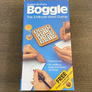 May include: A blue box for the Boggle board game. The box features a yellow hourglass, a yellow tray with letter cubes, and two hands writing on a notepad. The text on the box reads "Parker Brothers Boggle The 3-Minute Word Game".