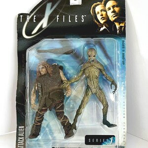 May include: The X-Files Series 1 Attack Alien action figures in original packaging. The package features images of the show's stars and the text "The X-Files" and "Fight the Future". The figures include a brown-clad figure and a green alien.