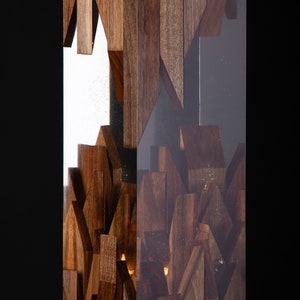 May include: A tall, rectangular sculpture made of wood and clear resin. The wood is arranged in a geometric pattern, creating a unique and modern design. The resin is clear and allows the wood to be seen through it.