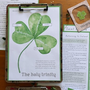 May include: A watercolor illustration of a green shamrock with the words "Son," "Father," and "Holy Spirit" labeled on its leaves. The text "The holy trinity" is at the bottom. A framed shamrock is in the background.
