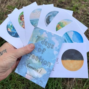 Puede incluir: Un conjunto de tarjetas blancas con ilustraciones circulares en acuarela que representan los 7 días de la creación. La tarjeta superior es azul con el texto 7 days of creation Genesis 1 y el nombre bush_school_kreatives.
