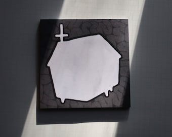 Può includere: Un'opera d'arte quadrata, grigio scuro, con un disegno bianco a forma di casa con una croce in cima. La forma della casa ha un effetto gocciolante in basso. Lo sfondo ha un motivo strutturato, simile alla pietra.