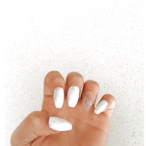 Könnte beinhalten: Weiße, sargförmige Acrylnägel mit einem einzigen Nagel, der ein blau-weißes Karomuster aufweist.