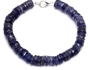 May include: A blue gemstone bracelet with a silver clasp. The bracelet is made of faceted beads and is approximately 7 inches in length.