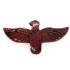 May include: A red, brown and black carved stone eagle with outstretched wings.