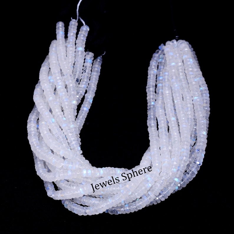 May include: A strand of white moonstone beads with a slight iridescent shimmer. The beads are faceted and have a smooth, polished finish. The strand is approximately 16 inches long and is perfect for making jewelry.