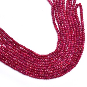 Może przedstawiać: Szereg fasetowanych koralików z czerwonego rubinu. Koraliki są małe i okrągłe, a nawleczone są na przezroczystą nić. Koraliki są ułożone w luźny, płynny wzór.