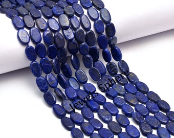May include: A strand of oval-shaped lapis lazuli beads. The beads are a deep blue color with flecks of gold pyrite. The beads are strung on a clear thread.