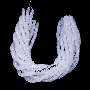 May include: A strand of white moonstone beads with a slight iridescent shimmer. The beads are faceted and have a smooth, polished finish. The strand is approximately 16 inches long and is perfect for making jewelry.