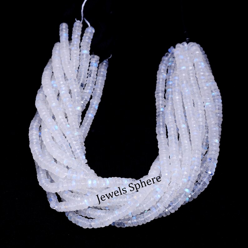 May include: A strand of white moonstone beads with a slight iridescent shimmer. The beads are faceted and have a smooth, polished finish. The strand is approximately 16 inches long and is perfect for making jewelry.