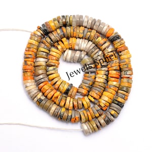 May include: A strand of yellow, brown, and gray gemstone beads. The beads are round and have a speckled pattern. The beads are strung on a white cord.