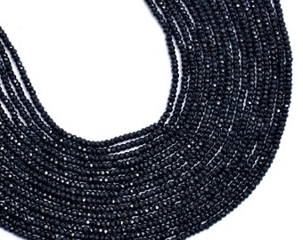 May include: A strand of black faceted gemstone beads. The beads are small and round, and they are strung together on a clear thread. The beads are arranged in a circular pattern, and they are all the same size and shape.