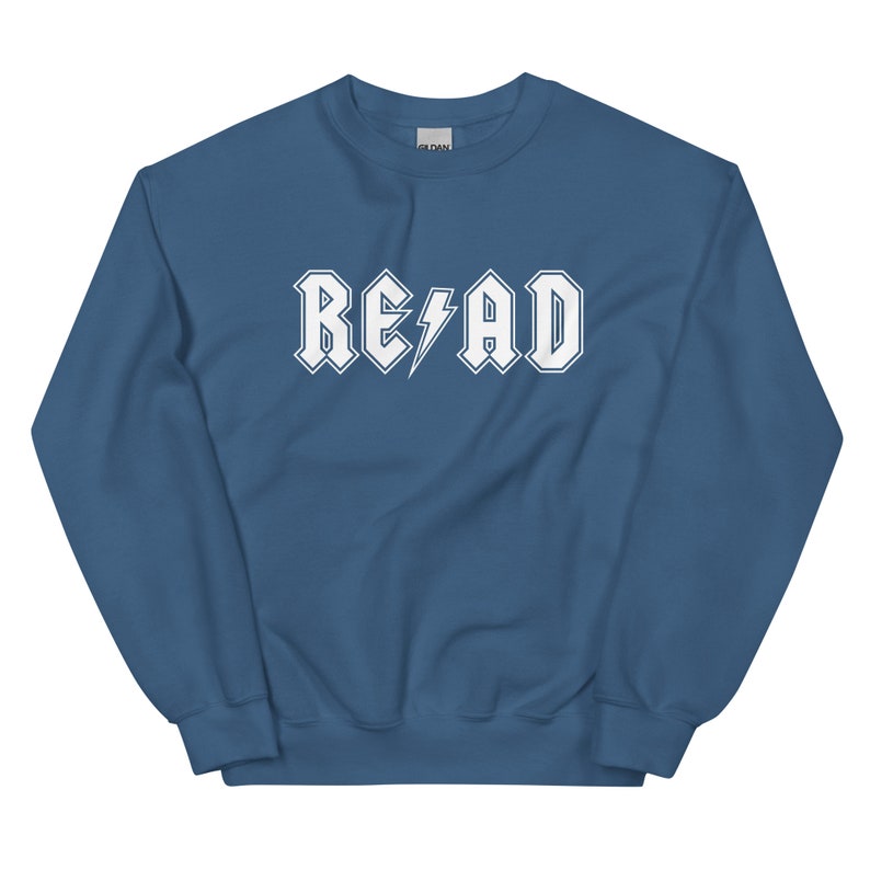 Puede incluir: Una sudadera azul con un gr&aacute;fico blanco que dice "RE&emsp;AD" en una fuente de rock and roll.