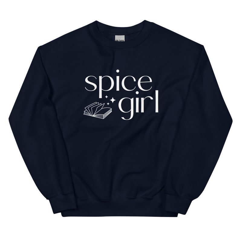 May include: A navy blue sweatshirt with the words "spice girl" in white script. A small open book graphic is below the words. The sweatshirt is a crew neck style.