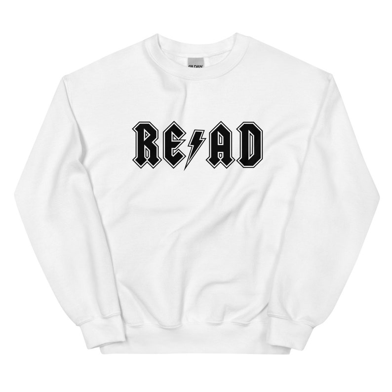 Puede incluir: Sudadera blanca con un estampado gr&aacute;fico negro de la palabra "READ" en una fuente de estilo rock and roll con un rayo.