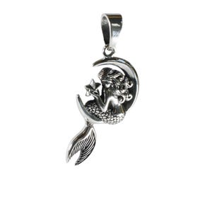 May include: A silver pendant featuring a mermaid sitting on a crescent moon, holding a star. The mermaid has a detailed tail and flowing hair.