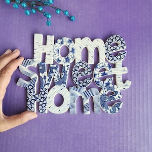 May include: White ceramic letters spelling "Home Sweet Home" with a blue and white floral pattern.