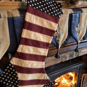 May include: A red, white and blue stocking with a star pattern. The stocking is hanging over a fireplace with a fire burning inside.