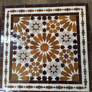 May include: A square table top with a geometric pattern of brown, white, and black tiles. The tiles are arranged in a repeating pattern of stars and flowers.