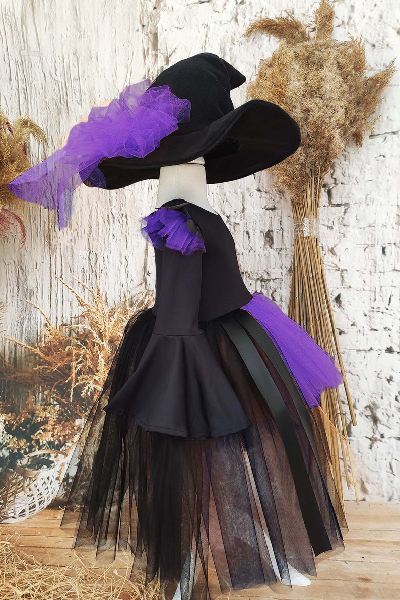 This enchanting toddler witch costume is perfect for girls looking to embrace Halloween in style. It features a black and orange asymmetrical gothic tutu dress and a matching witch hat.