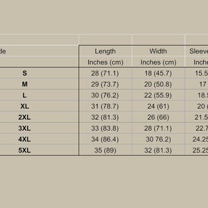 May include: A size guide chart with measurements in inches and centimeters. The chart includes sizes S to 5XL, with corresponding length, width, and sleeve length measurements. The background is a light tan color.
