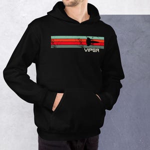 Puede incluir: Sudadera con capucha negra con un gráfico retro de una nave espacial con la palabra "VIPER" impresa debajo.
