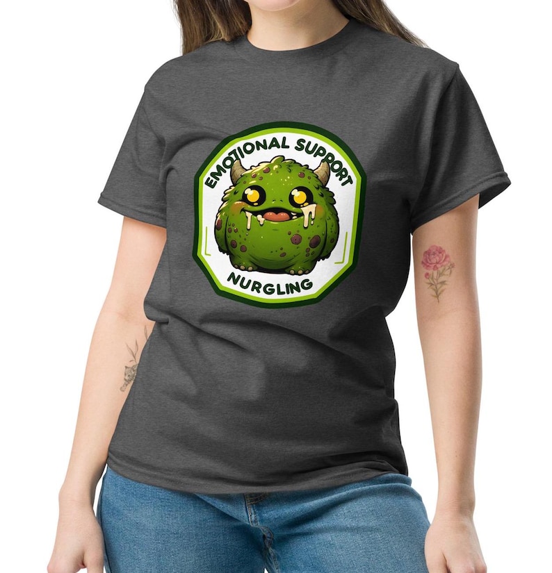 Puede incluir: Una camiseta gris oscuro jaspeada con un monstruo verde de dibujos animados que lleva una diadema blanca con el texto "Emotional Support Nurgling".
