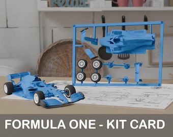 Può includere: Un kit di modellismo in plastica blu di un'auto di Formula Uno. Il kit include la carrozzeria dell'auto, le ruote e altri pezzi. Il kit è mostrato su un tavolo bianco con un progetto dell'auto.