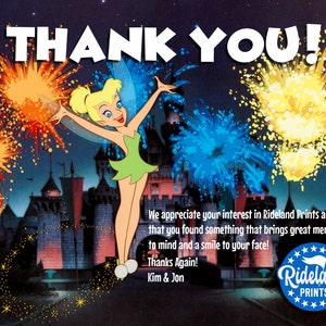 Puede incluir: Una tarjeta de agradecimiento con Campanilla de Peter Pan de Disney, con un espect&aacute;culo de fuegos artificiales nocturnos sobre un castillo en el fondo. La tarjeta incluye el texto "THANK YOU!" y "Rideland Prints".