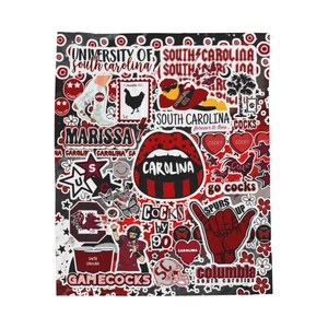 Może przedstawiać: Prostokątny koc z kolażem grafik o tematyce University of South Carolina w kolorach czerwonym, czarnym i białym. Elementy obejmują napisy Carolina, Gamecocks, Columbia, postać gracza futbolu, koguta, usta oraz gwiazdki.
