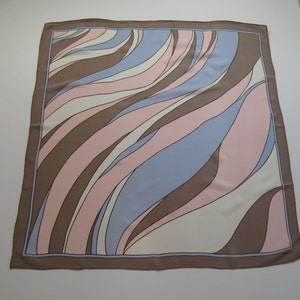 May include: A square silk scarf with a brown, pink, and blue abstract pattern. The pattern features curved lines and swirls.