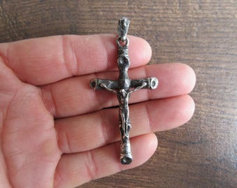 May include: A silver crucifix pendant with a detailed figure of Jesus Christ on the cross.