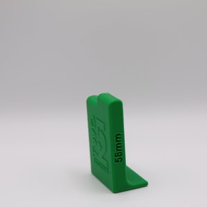 May include: Green plastic corner piece with the text "58mm" printed on the side.