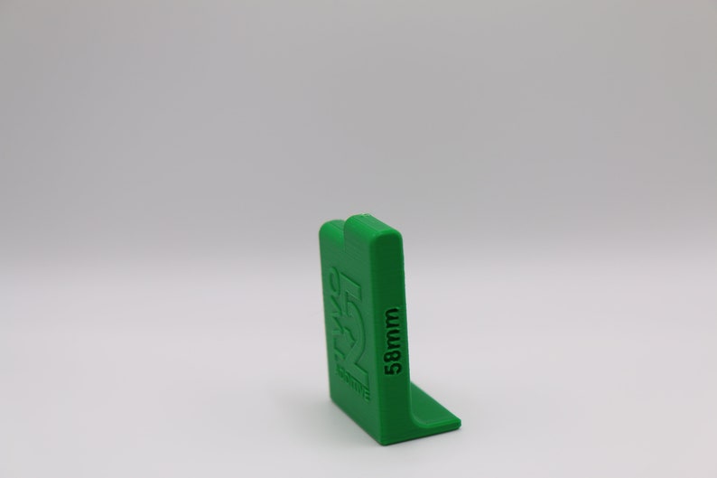 May include: Green plastic corner piece with the text "58mm" printed on the side.