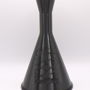 May include: A black plastic bottle with a narrow neck and a wide, conical base. The bottle is labeled "TWO 51 ADDITIVE".