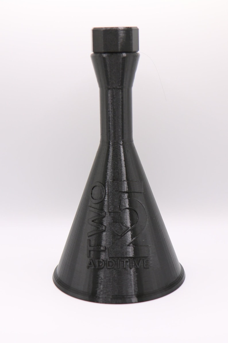 May include: A black plastic bottle with a narrow neck and a wide, conical base. The bottle is labeled "TWO 51 ADDITIVE".