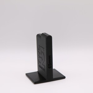 May include: Black plastic tile spacer with the text "65mm" and "ACTIVE" printed on the side.